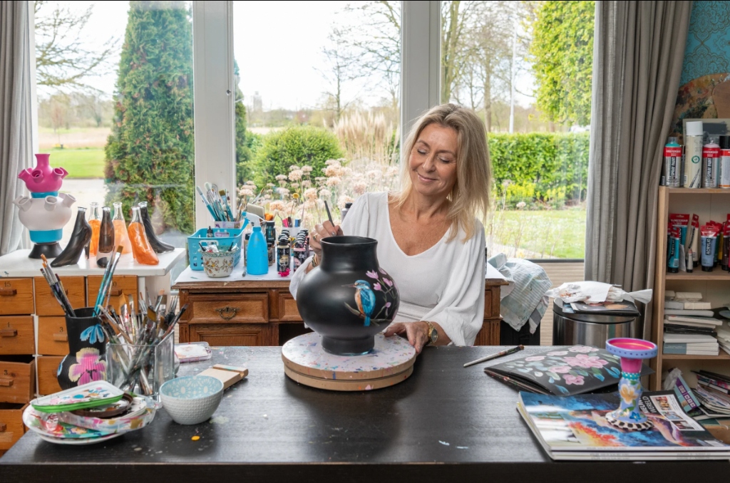 Saskia van Atelier Goudkust schildert handgemaakte keramieken vaas